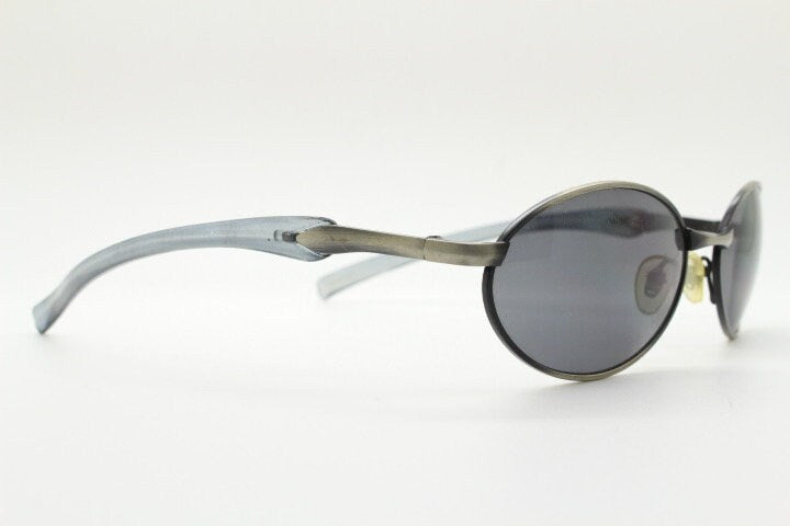 90s vintage small oval  bug eye sunglasses. Brushed bronze finish frame with transparent grey arms. Y2K. 2000s. Unworn NOS