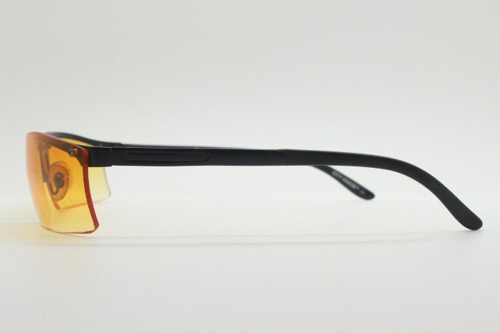 Y2K vintage half frame visor sunglasses. 2000's black brow line with light tone blazing orange rectangular curved lenses. 00's