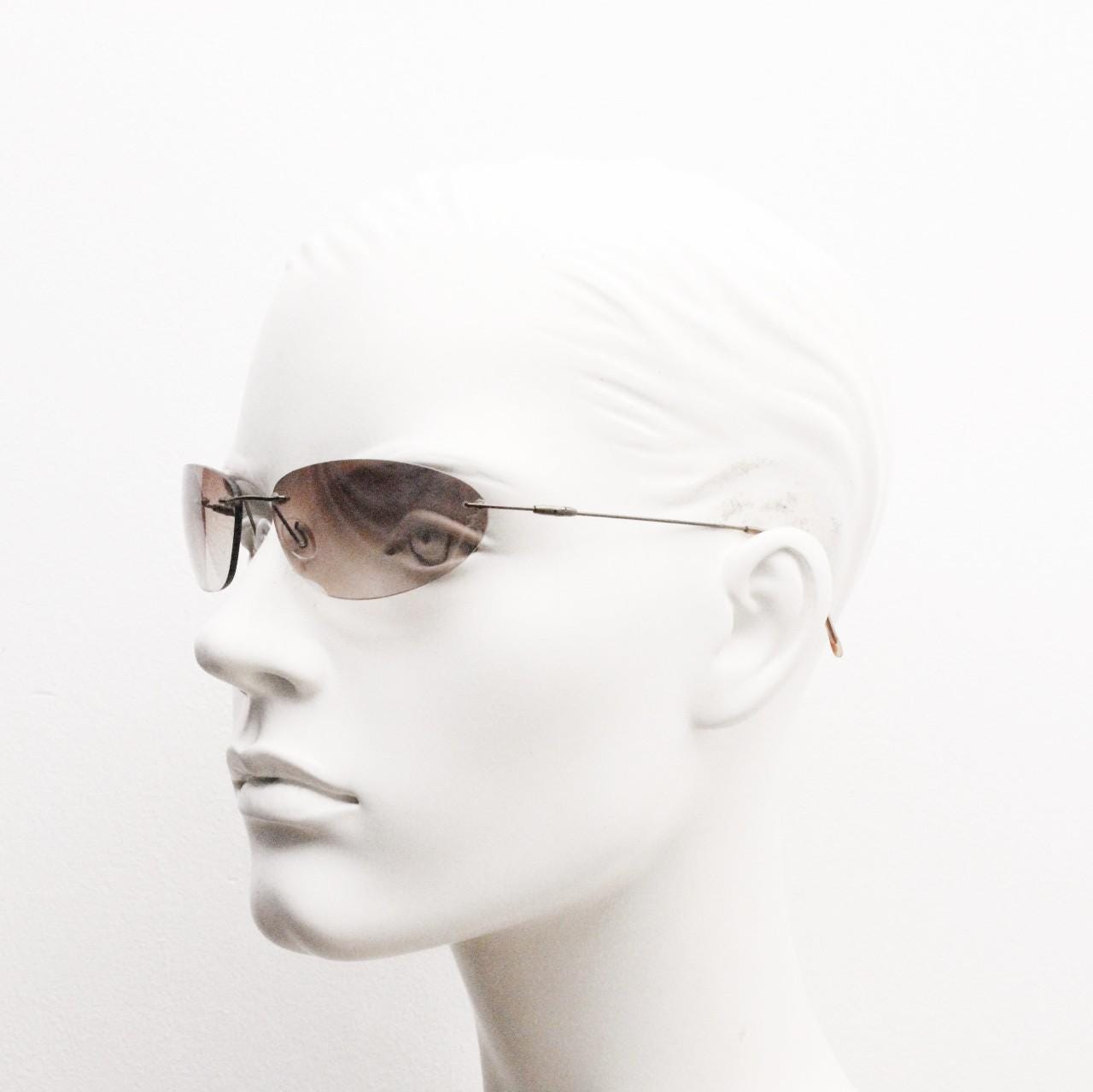 90s vintage frameless oval wraparound sunglasses. Minimal curved almond shaped lenses with brown chrome arms. 2000s NOS. Matrix cosplay