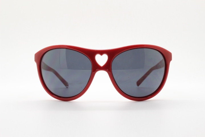 Moschino oversized Y2K vintage sunglasses. Characteristic crimson red acetate frame with cut out heart bridge. 2000s