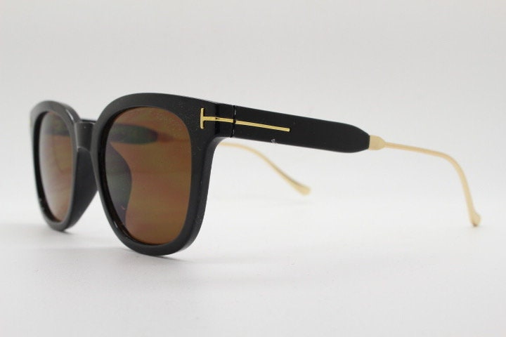 Tom Ford vintage wayfarer design sunglasses made in Italy. Slightly cat eye form in plain black gloss acetate with gold arms
