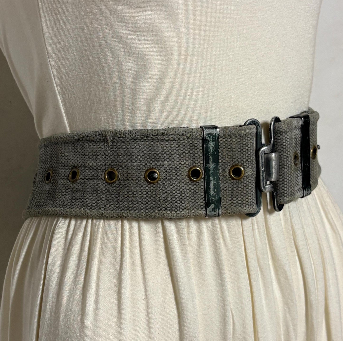 80s vintage real army webbing belt. Thick woven canvas in khaki green. Distressed look. Metal hardware. Fully adjustable. Tactical webbing