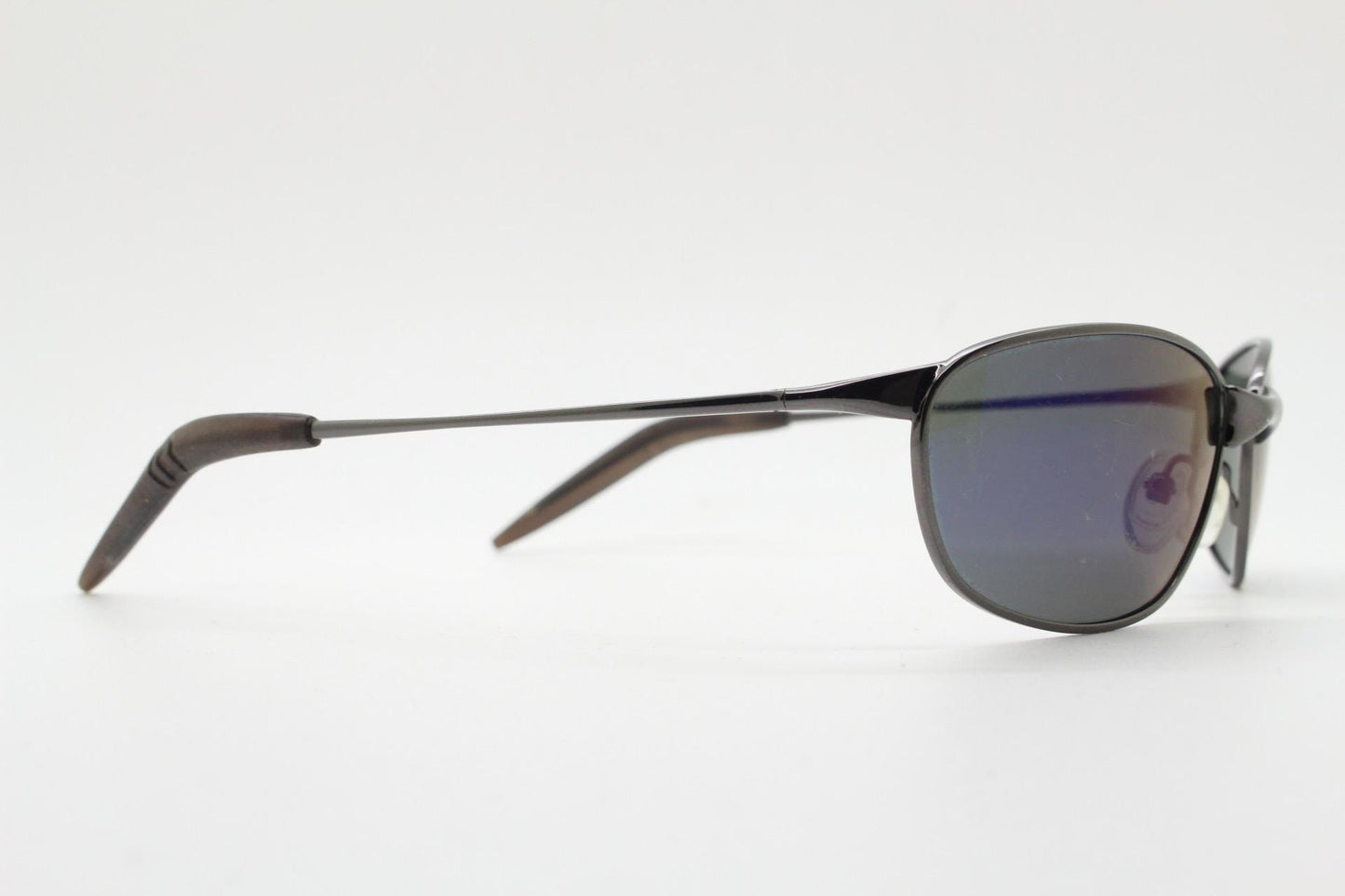 90s vintage curved oval sunglasses. Solid metal low profile frame in grey chrome with slightly mirrored dark lenses. 2000's. Y2K NOS