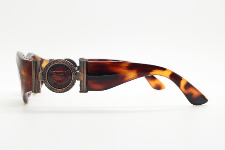 90s vintage oval sunglasses. Low profile transparent tortoise frame with massive bronze metal arm crests BNWT. Unused NOS