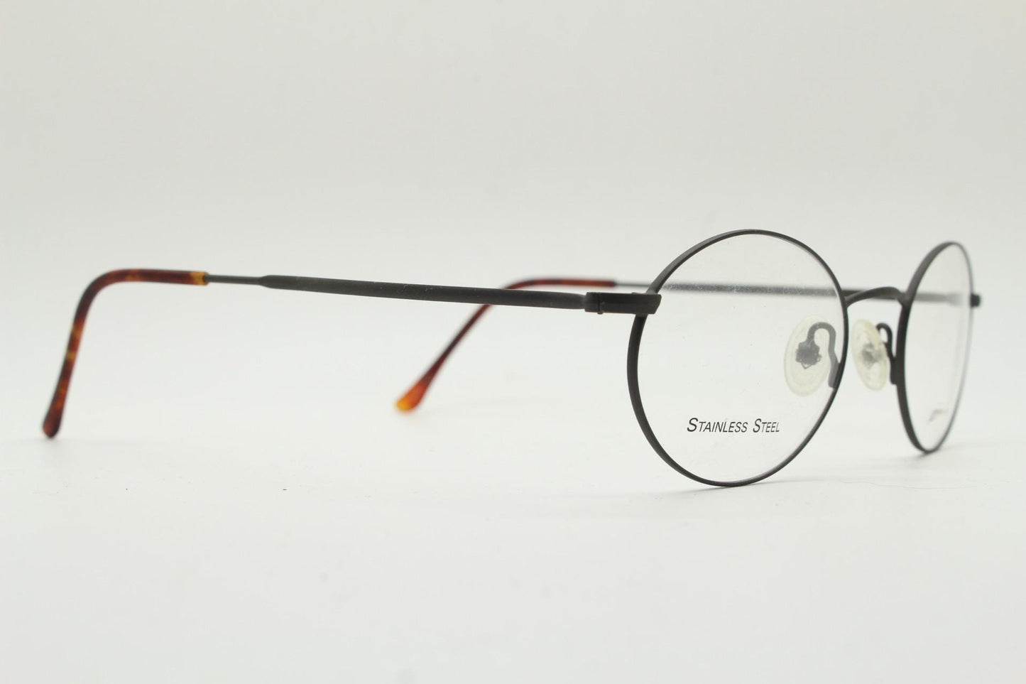 Eddie Bauer 90s vintage oval eye glasses. Minimal black matt finish optical frames with kinked arms. Stainless steel spectacles. NOS