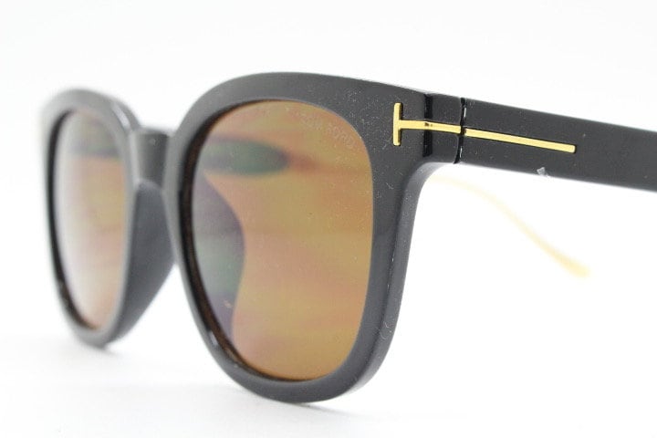 Tom Ford vintage wayfarer design sunglasses made in Italy. Slightly cat eye form in plain black gloss acetate with gold arms