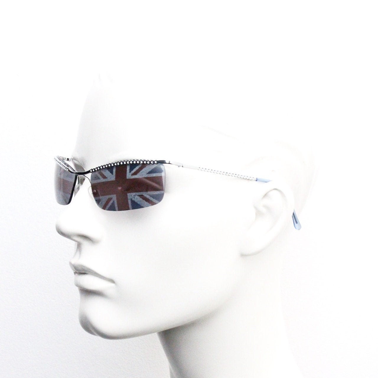 90s vintage half frame Union Jack sunglasses. Curved lens suspended on a sparkling chrome brow. Unused NOS. Brit pop girl power