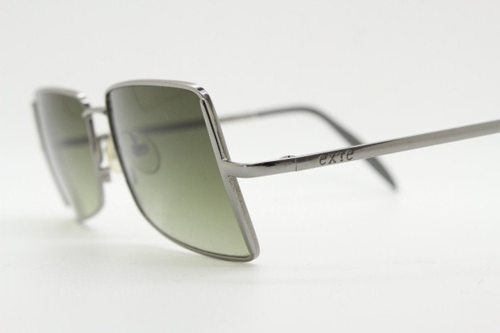 Exte rectangular 90s vintage sunglasses made in Italy. Grey chrome low profile frame with graduating green lenses