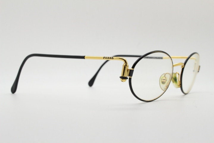 Gianfranco Ferre 90s vintage oval eye glasses made in Italy. Black and gold metal tech design optical frame. Prescription RX. NOS