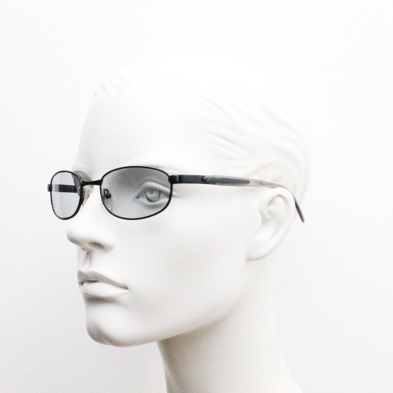 90s vintage oval small bug eye sunglasses. Curved black satin finish metal frame with transparent grey arms and light tone lenses. NOS