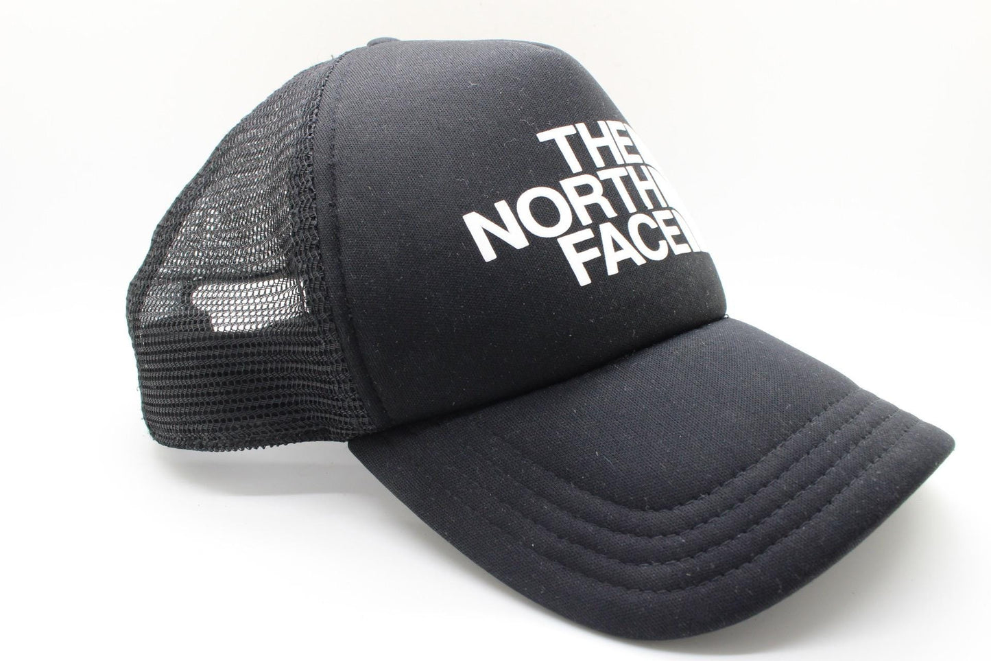 The North Face plain black baseball cap with big white spell out logo. Classic trucker style hat with fully adjustable back
