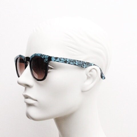 80s vintage rounded wayfarer design sunglasses. Abstract patterned blue brow and arms on a black frame with graduating  lenses. Unused NOS