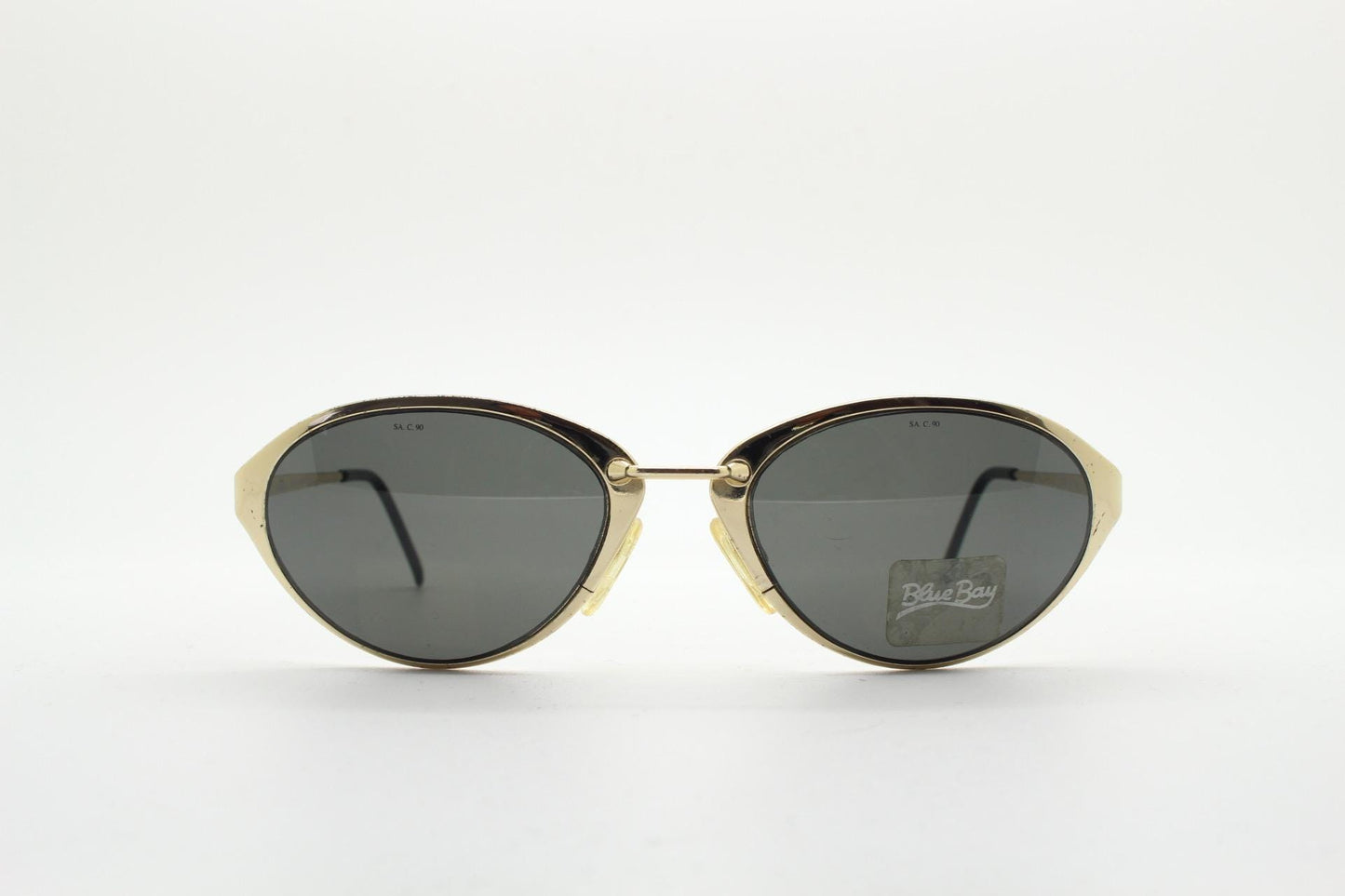 Blue Bay 90s vintage oval cat eye sunglasses made in Italy by Safilo. Dynamic gold chrome finish with contrasting dark lenses. NOS with tag