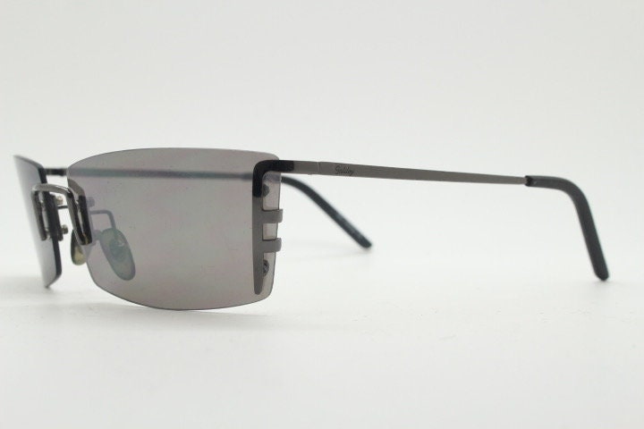 Y2K vintage wraparound sunglasses. Dynamic frameless shield design in gunmetal grey with slight mirror glaze rectangular lenses. 2000's NOS
