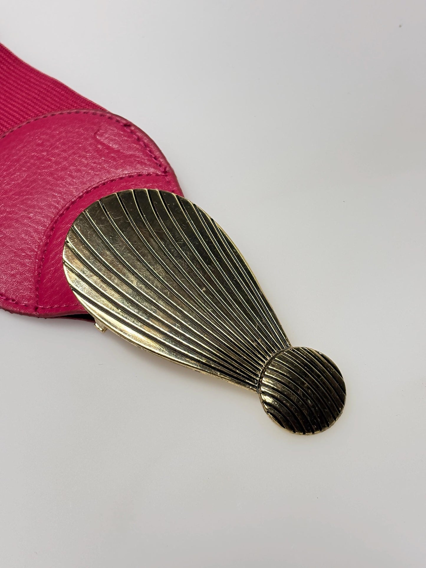 80s vintage womens tall pink elastic belt. Large winged silver and gold buckle. Flattering cinch effect. Adjustable stretchy size range