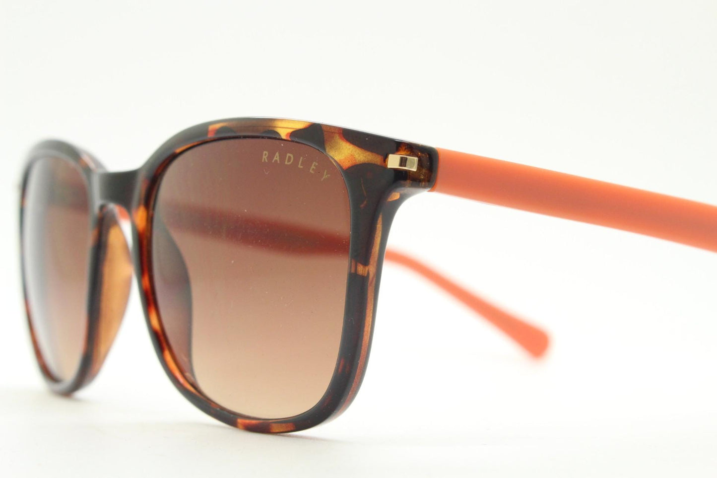 Modified wayfarer design sunglasses by Radley. Tortoise front with bright orange arms and Havana brown lenses. Vintage. Unused NOS