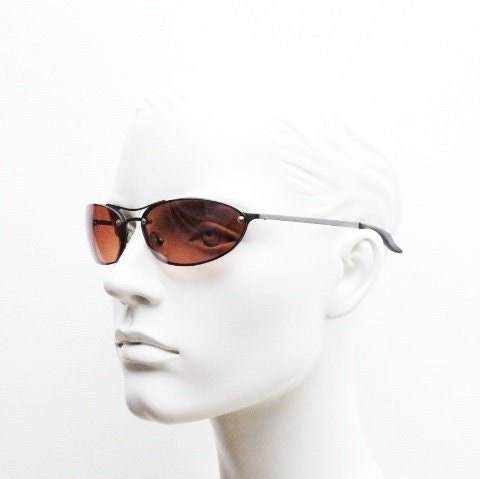 Y2K vintage oval sunglasses. Satin finish grey metal frame with amber curved almond bug eye lenses and straight arms. 2000's. NOS