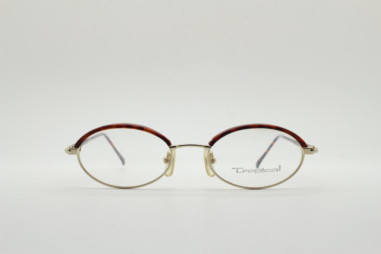 90s vintage small oval eye glasses by Tropical. Minimal gold optical frames with tortoise arms and brows. Prescription RX spectacles. NOS