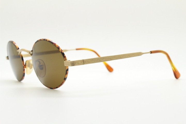 Armandos 90s vintage oval sunglasses made in Italy. Enamelled honey tortoise front with ornate tooled metal arm patterns. NOS