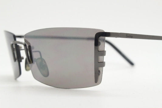 Y2K vintage wraparound sunglasses. Dynamic frameless shield design in gunmetal grey with slight mirror glaze rectangular lenses. 2000's NOS