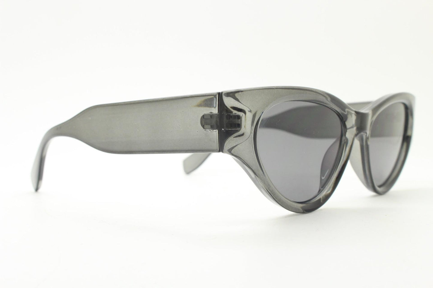 Thick cateye sunglasses with cropped sides and sharp outline. Womens 60s design chunky transparent grey frame and lenses. Y2k vintage