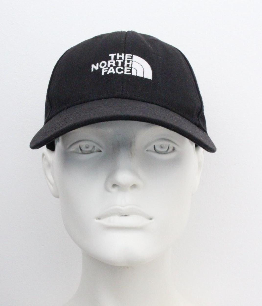 The North Face plain black baseball cap with white spell out logo. Classic trucker style hat with fully adjustable back. One size