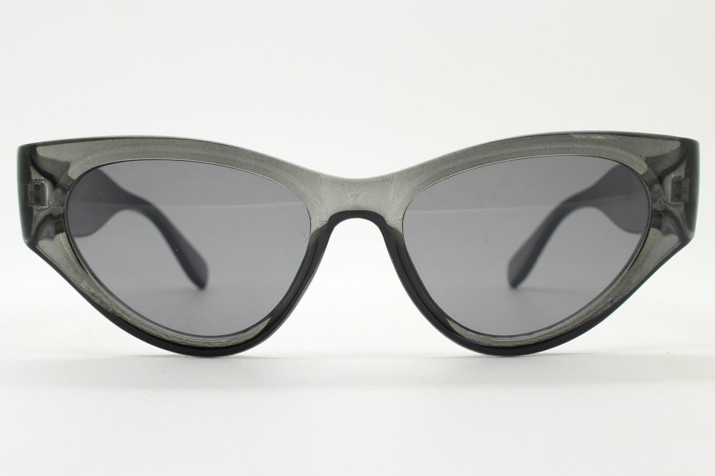 Thick cateye sunglasses with cropped sides and sharp outline. Womens 60s design chunky transparent grey frame and lenses. Y2k vintage