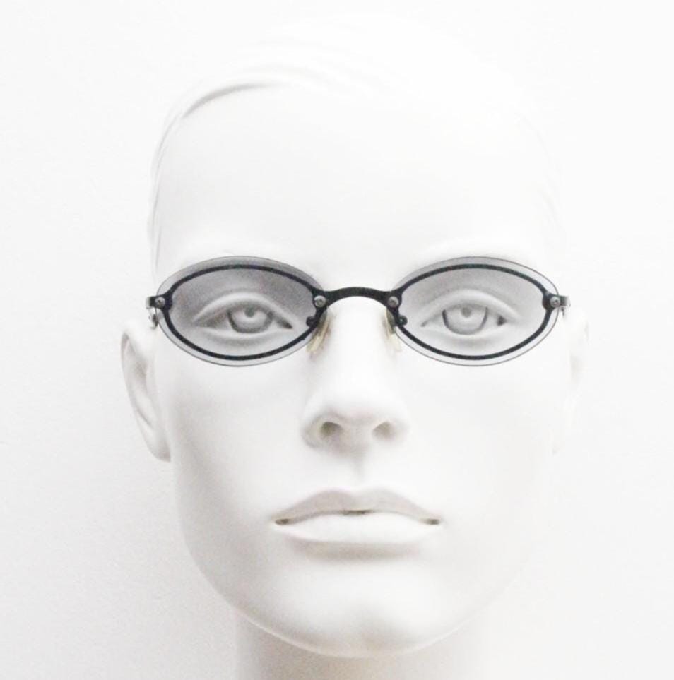 90s vintage small oval sunglasses. Minimal black metal frame with clever overlapping lens design in light tone grey. Micro. Steampunk. NOS