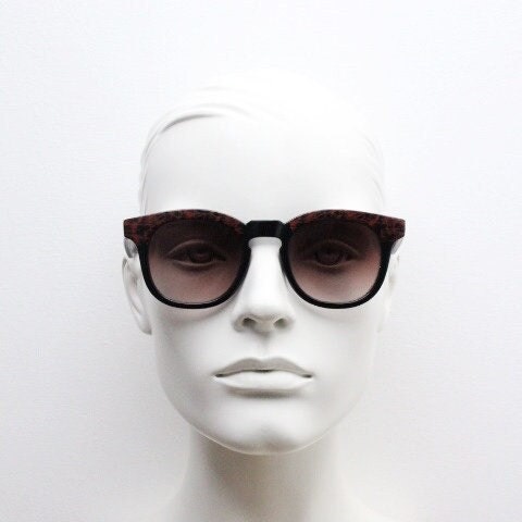 80s vintage rounded wayfarer design sunglasses. Abstract patterned red brow and arms on a black frame with graduating  lenses. Unused NOS