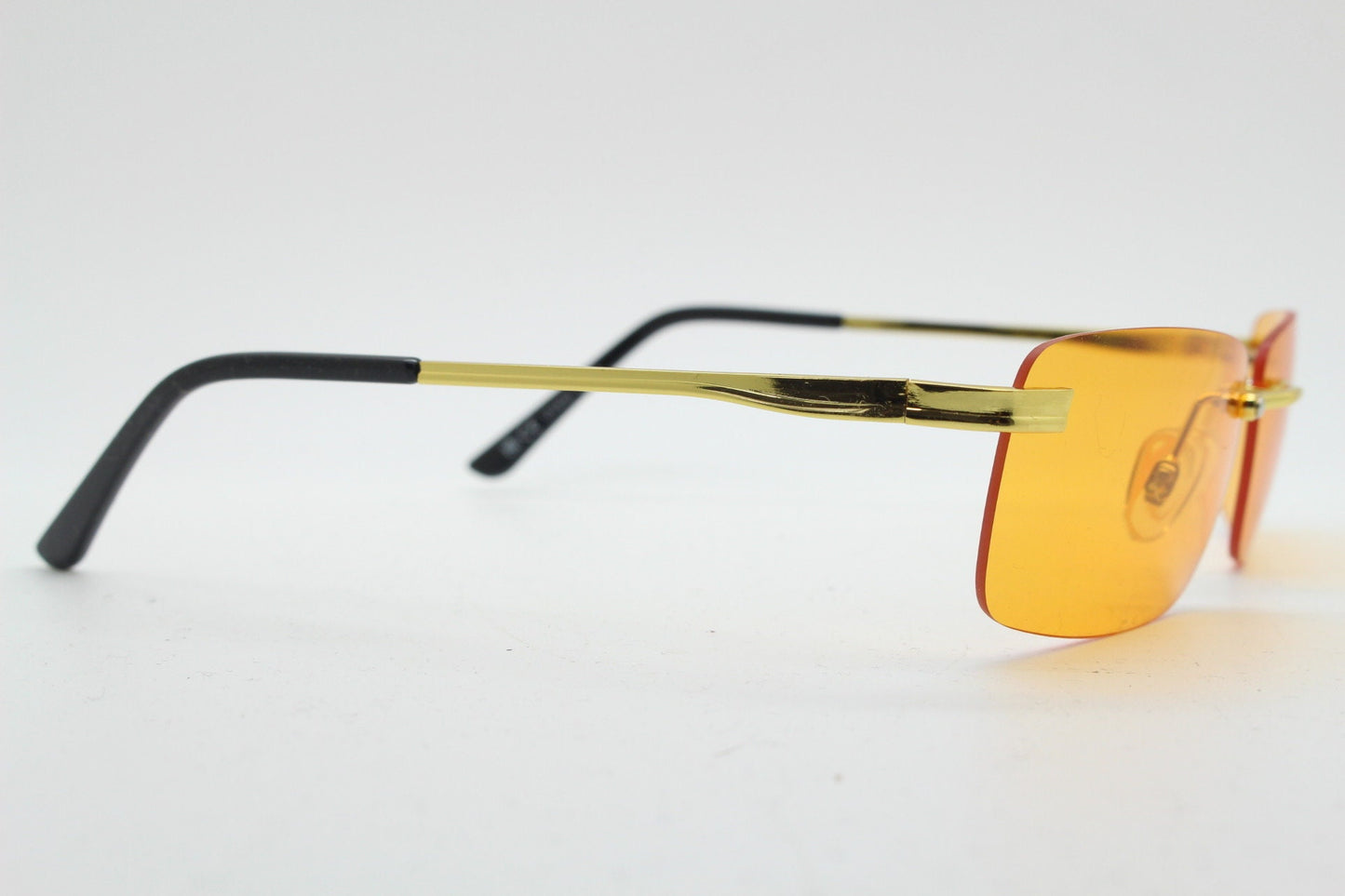 Y2K vintage frameless orange sunglasses. Rectangular lenses with gold bridge and arms. 2000s club kids. 00's. 90s Rave
