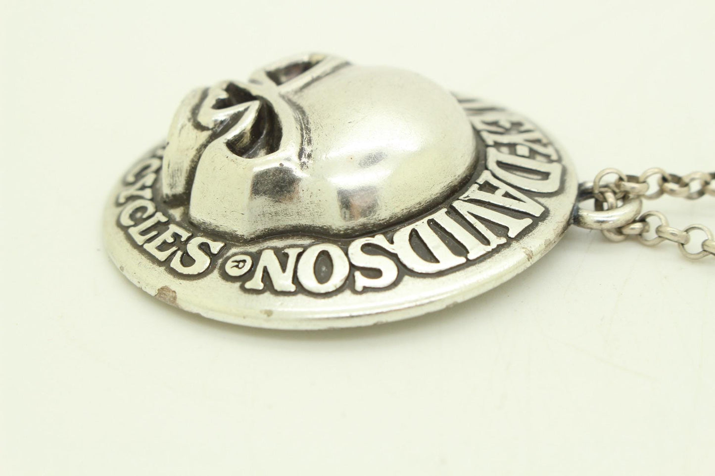 90s vintage Harley Davidson Motorcycles disc pendant necklace. Solid metal silver curved shield with standout skull on adjustable chain