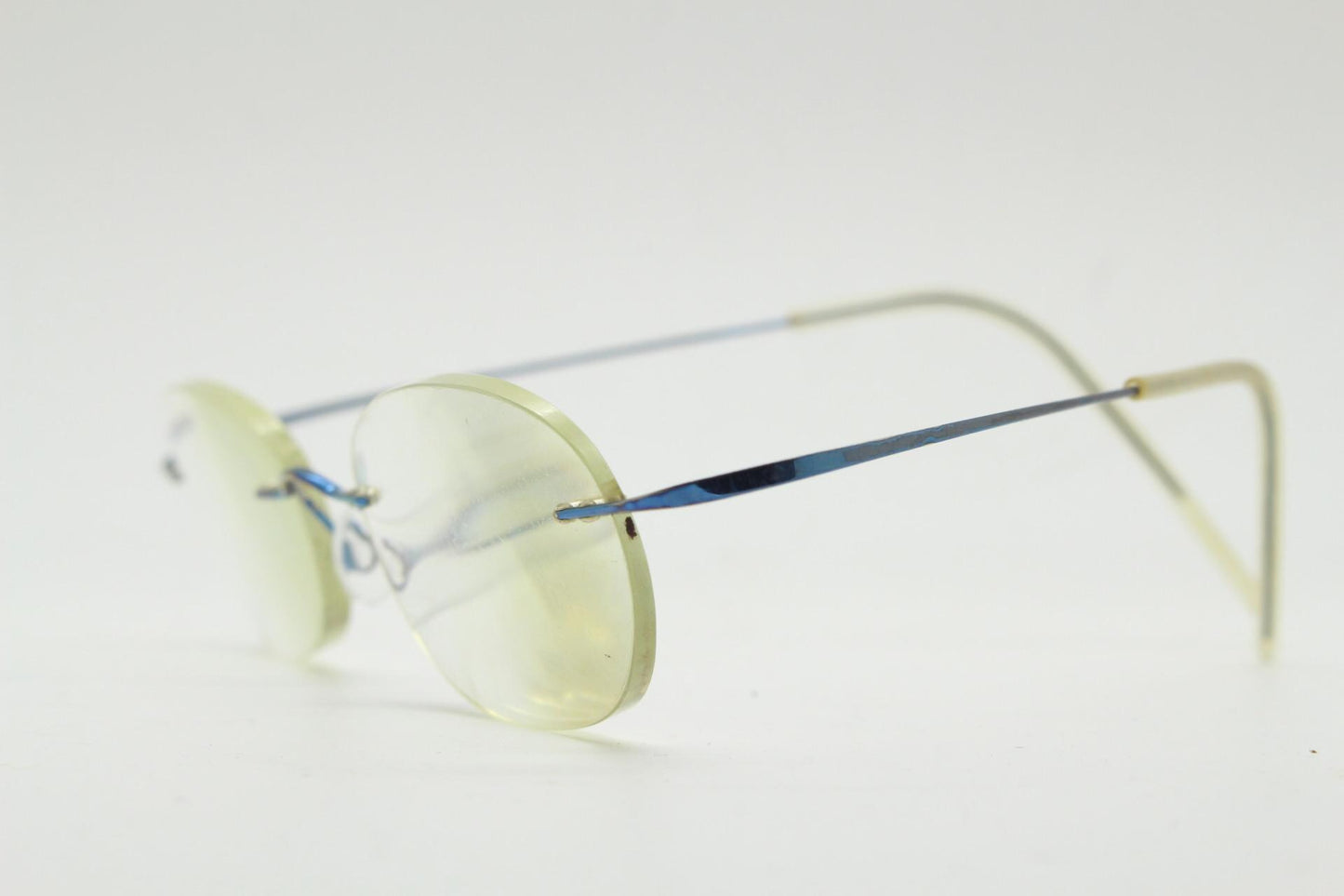 Frameless vintage oval eye glasses. Extremely minimal lightweight blue titanium optical frame with springy hingeless arms. 2000s