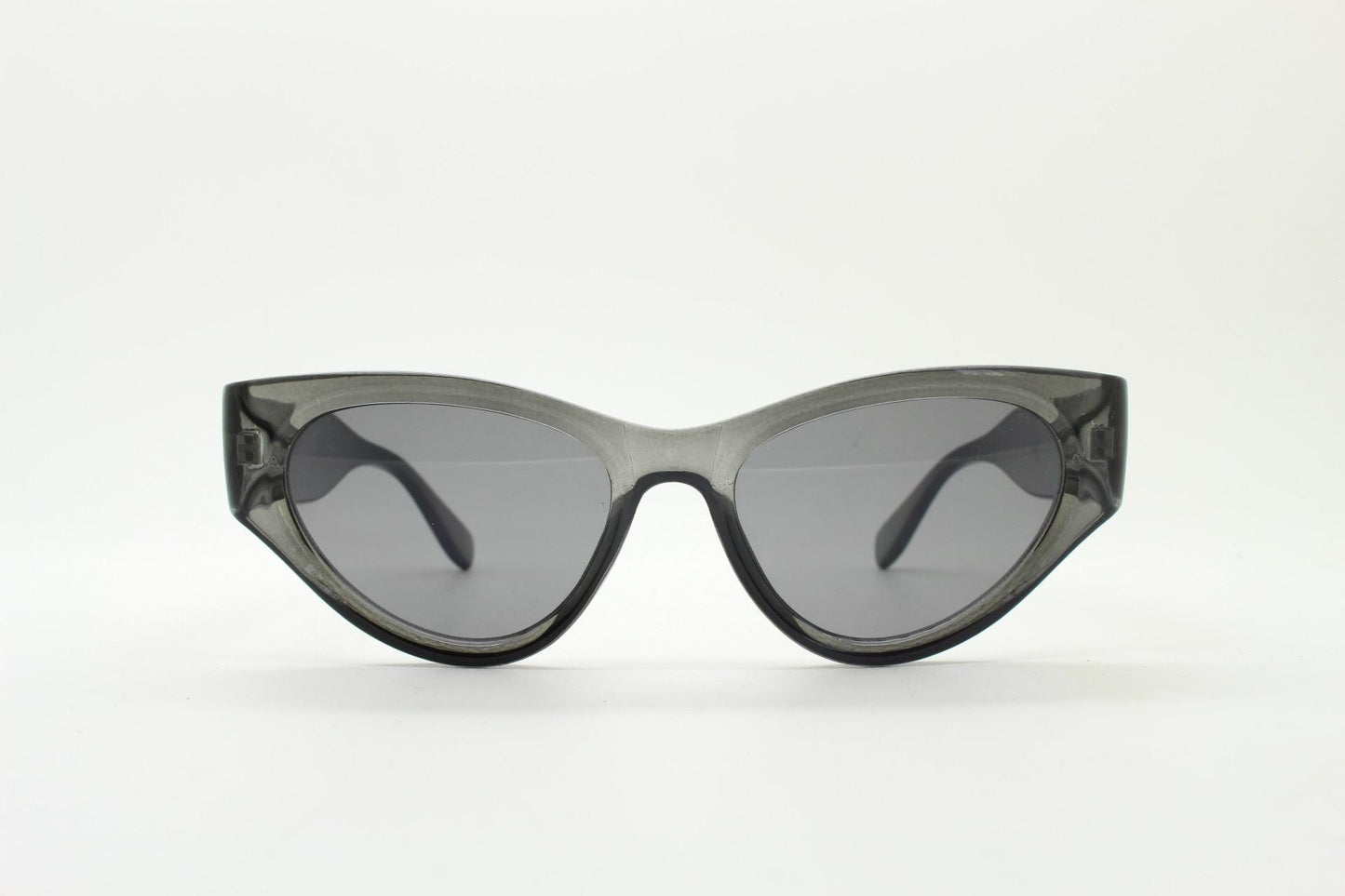 Thick cateye sunglasses with cropped sides and sharp outline. Womens 60s design chunky transparent grey frame and lenses. Y2k vintage