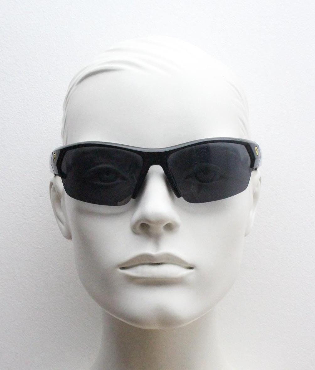 A mannequin head wearing black sunglasses against a white background.