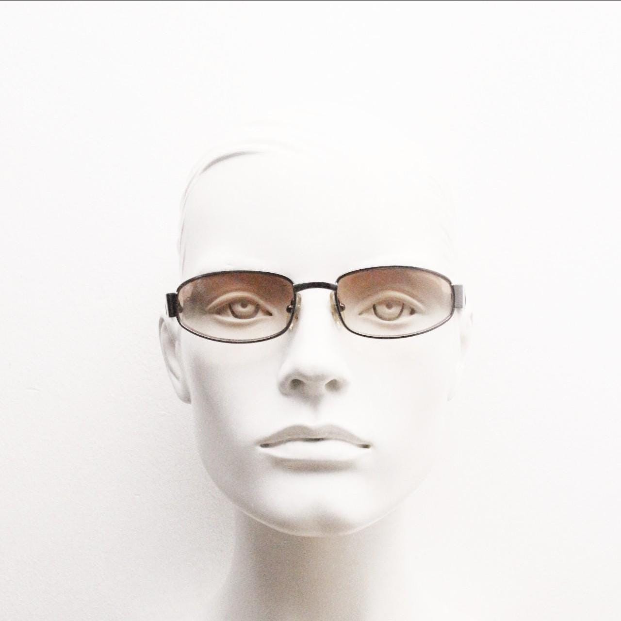 90s vintage oval sunglasses small bug eye with light tone lenses. Satin finish brown metal frame with black arms. 2000's. NOS