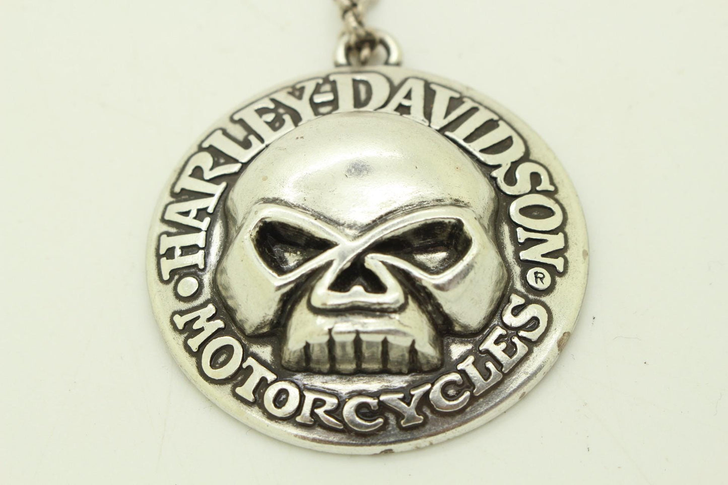 90s vintage Harley Davidson Motorcycles disc pendant necklace. Solid metal silver curved shield with standout skull on adjustable chain