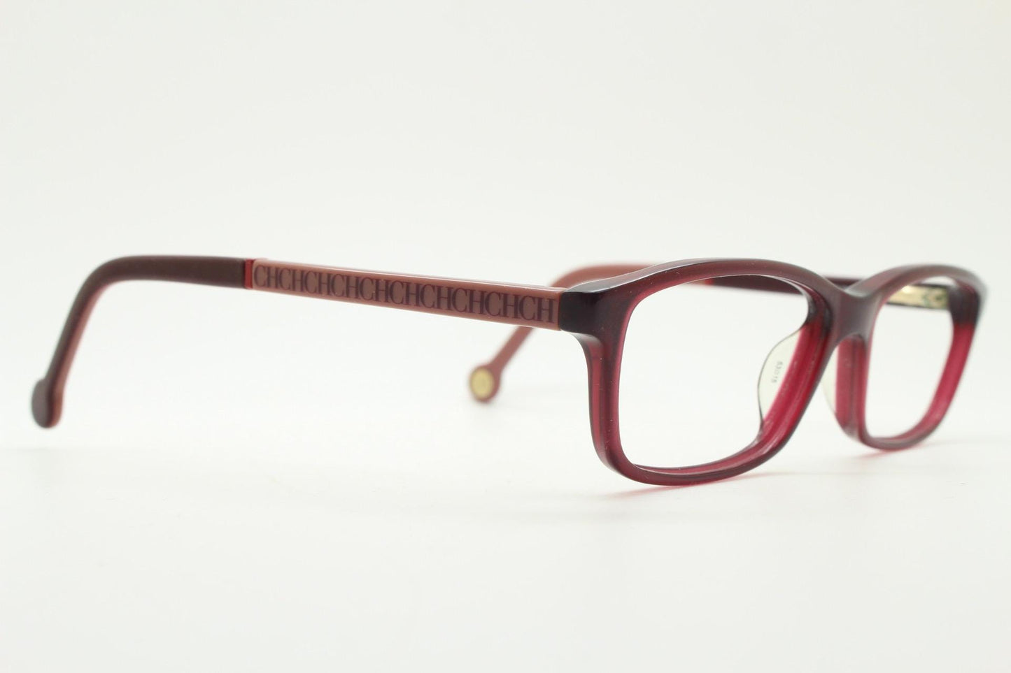 Carolina Herrera rectangular low profile eye glasses. Dark pink acetate optical frames with tasteful arm logo. Prescription RX eyeglasses