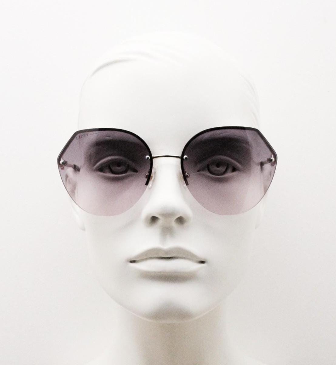 Large rimless sunglasses with dynamic angular grey to pink  graduating lenses. Women's 80s vintage style half frame with gold arms