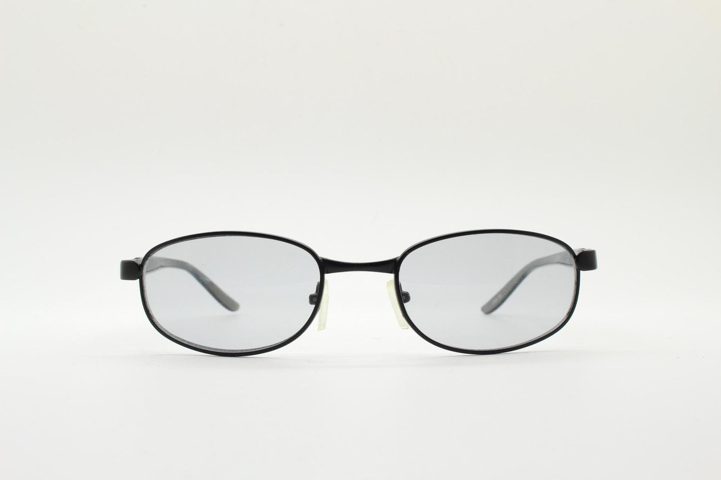 90s vintage oval small bug eye sunglasses. Curved black satin finish metal frame with transparent grey arms and light tone lenses. NOS