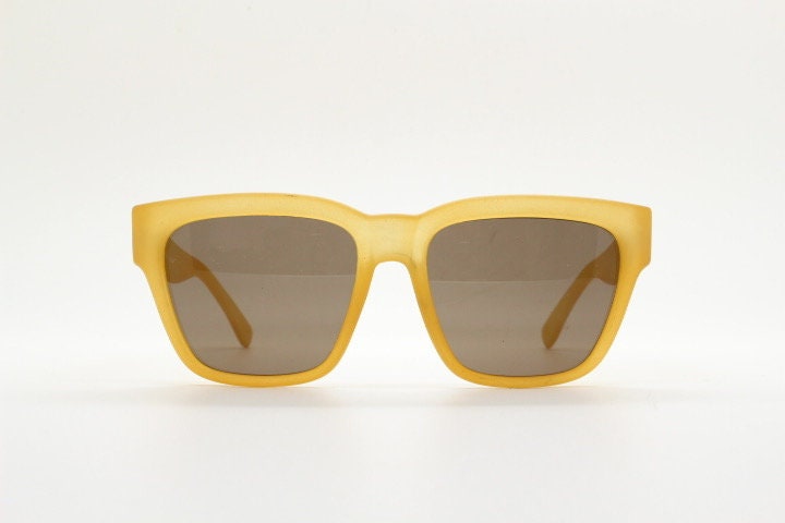 IDC lunettes modified wayfarer design sunglasses made in France. Transparent frosted yellow acetate chunky frame with contrasting lenses