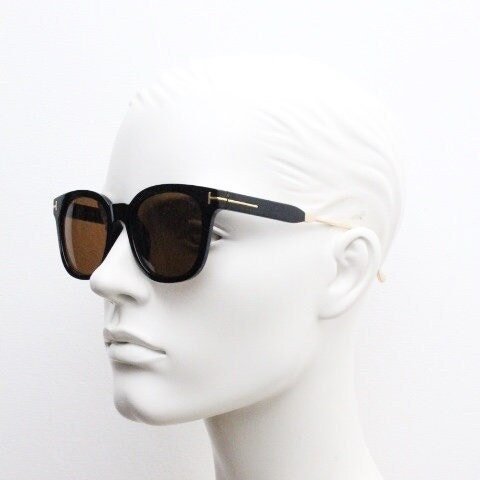Tom Ford vintage wayfarer design sunglasses made in Italy. Slightly cat eye form in plain black gloss acetate with gold arms