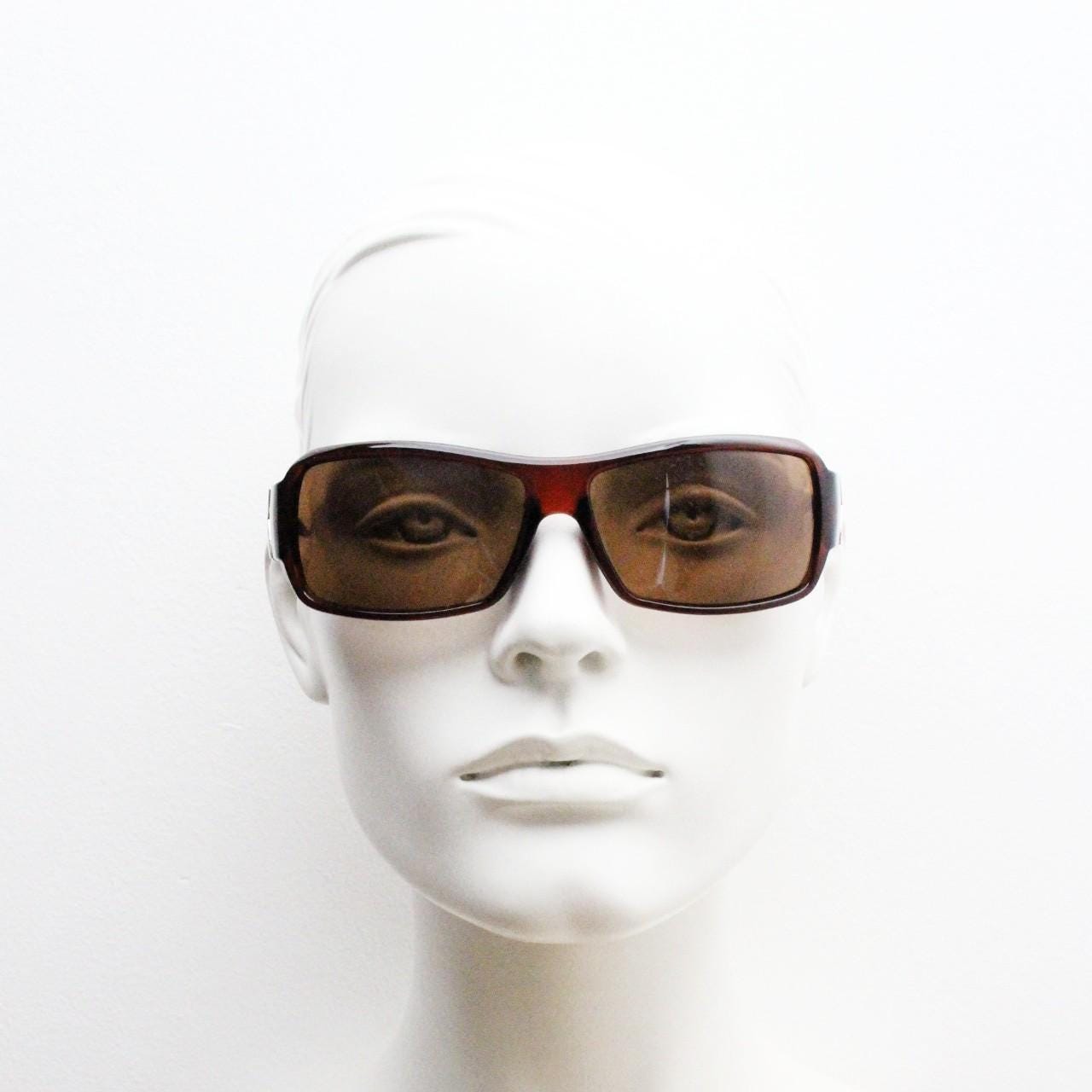 Y2K vintage visor sunglasses. Transparent brown wrap around shield with curved lenses and big X crest. 2000s biker bug eye. NOS