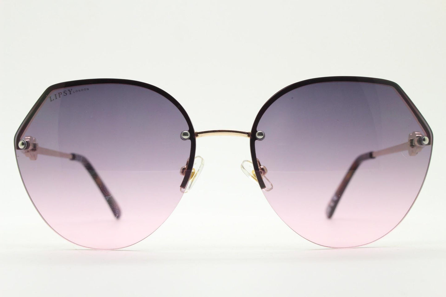 Large rimless sunglasses with dynamic angular grey to pink  graduating lenses. Women's 80s vintage style half frame with gold arms