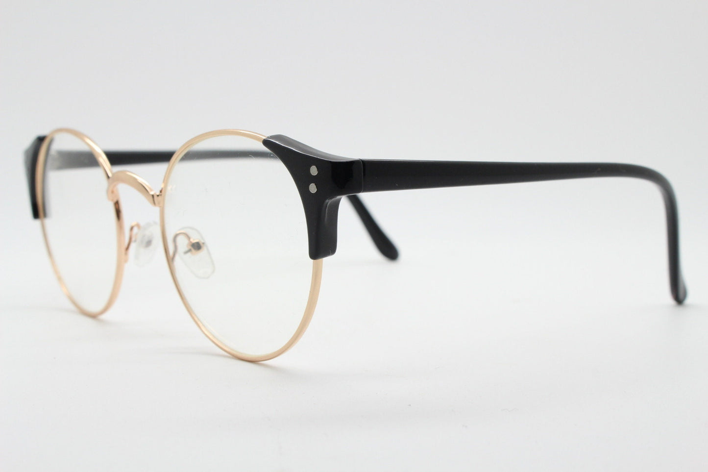 90s vintage modified cat eye glasses. Black arms with a round gold face. 40s, 50s style clear lens eyeglasses. Cateye