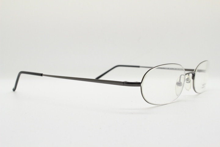 Police 90s vintage oval half rim eye glasses made in Italy. Minimal lightweight optical frame in gunmetal grey. Prescription RX Spectacles