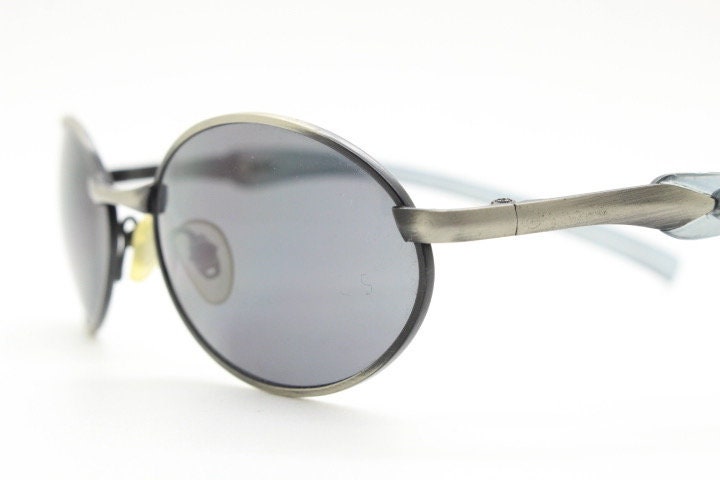 90s vintage small oval  bug eye sunglasses. Brushed bronze finish frame with transparent grey arms. Y2K. 2000s. Unworn NOS