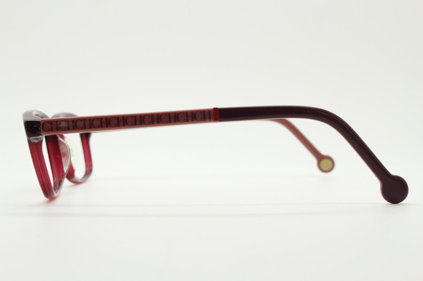 Carolina Herrera rectangular low profile eye glasses. Dark pink acetate optical frames with tasteful arm logo. Prescription RX eyeglasses