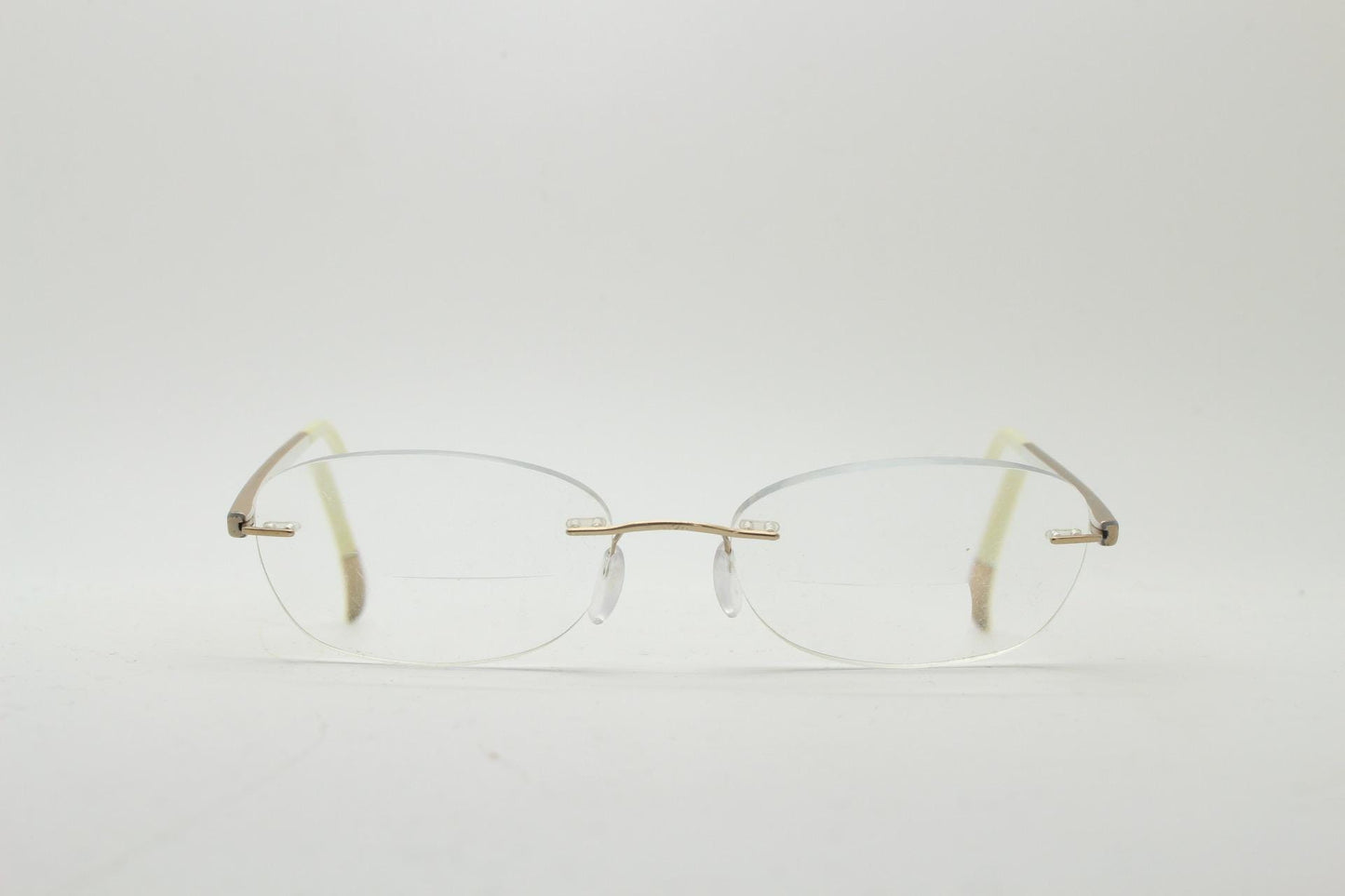Silhouette rectangular frameless eye glasses made in Austria. Minimal lightweight gold with white enamel frame. 90s vintage. Prescription RX