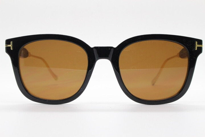 Tom Ford vintage wayfarer design sunglasses made in Italy. Slightly cat eye form in plain black gloss acetate with gold arms