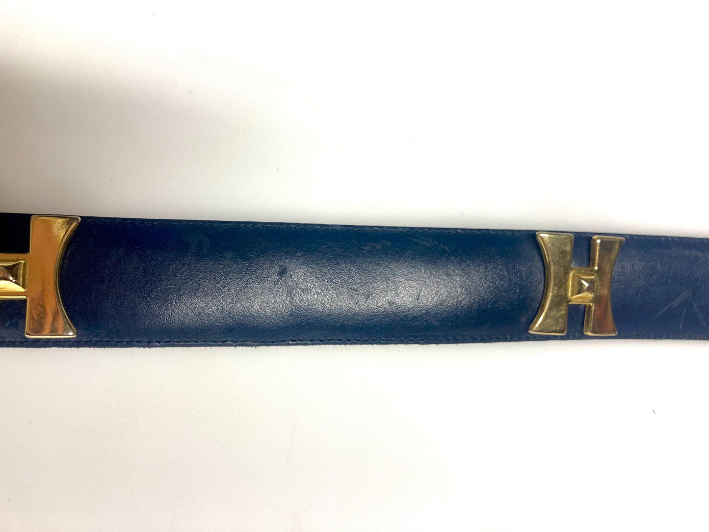 80s vintage womens dress belt in navy blue genuine leather with substantial gold chrome studded 'H' motifs. Made in France. Size S